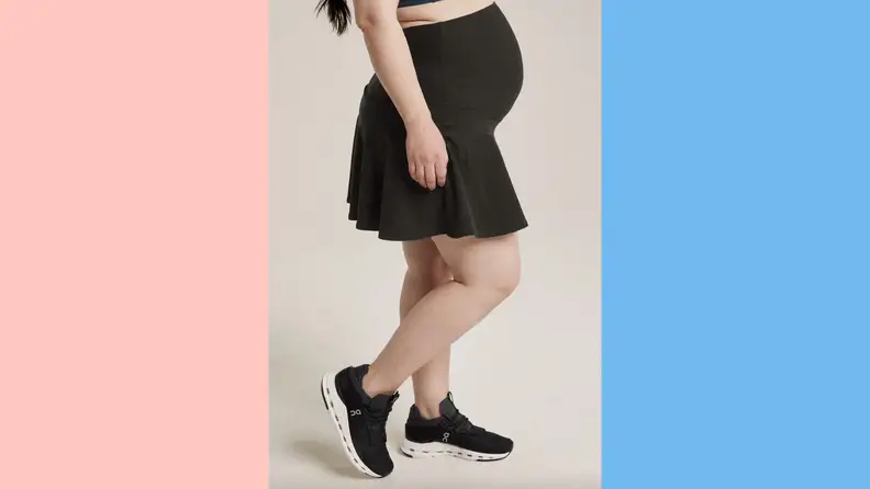 A pregnant woman wearing a sporty maternity skirt by BeyondYoga.
