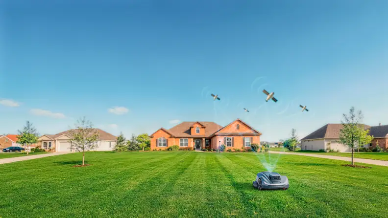 A Sunseeker Elite robotic mower operates on a large suburban front lawn with satellite positioning illustrated overhead.