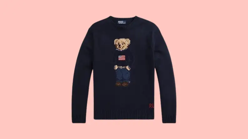 A navy sweater knit with a pattern of the Polo Bear wearing an American Flag sweater with jeans and a belt.