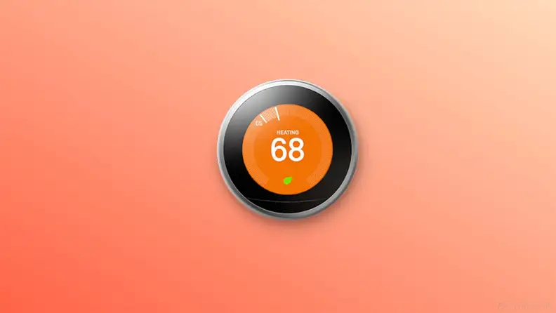 Google nest thermostat on orange background.