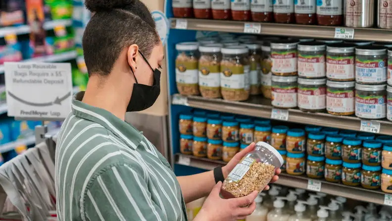 A person reads nutritional value on a packaged product.