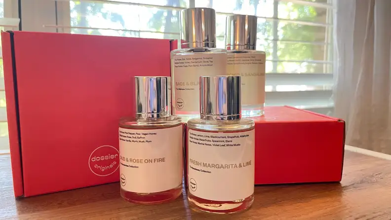 Four bottles of perfume arranged on red boxes.