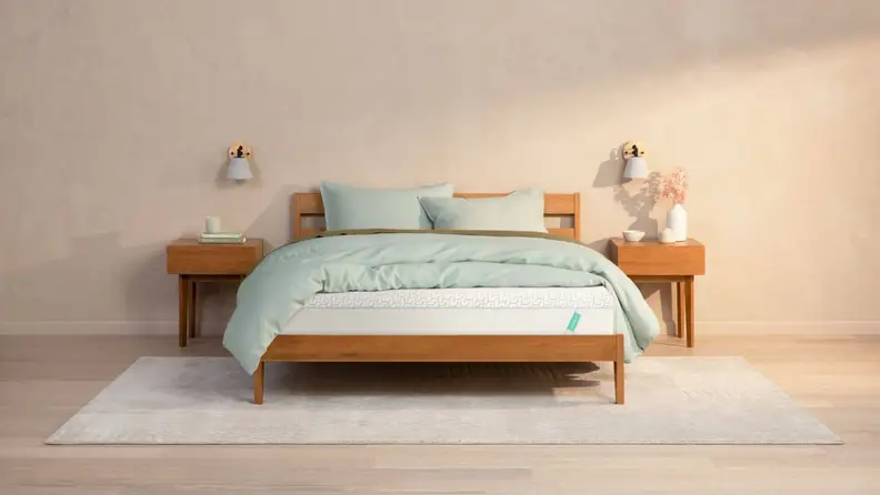A Tuft & Needle mattress in a warmly lit room