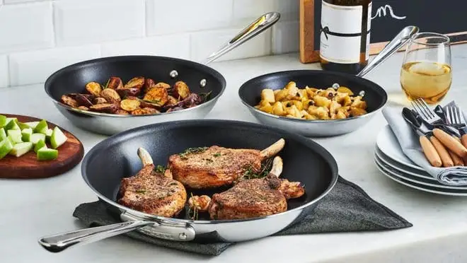 Three pans on a stove cooking various food items