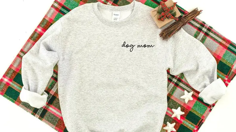 An image of a gray sweatshirt embroidered with the words "dog mom."