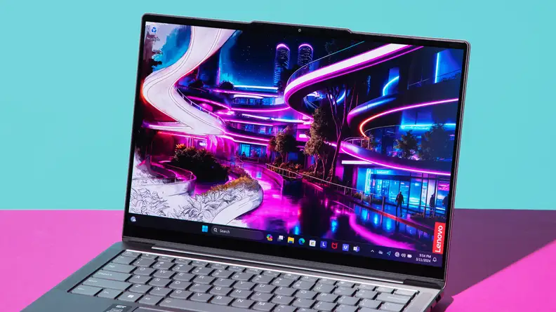 The Lenovo Slim 7 with an abstract wallpaper on screen on top of a purple desk next to a blue paper weight.