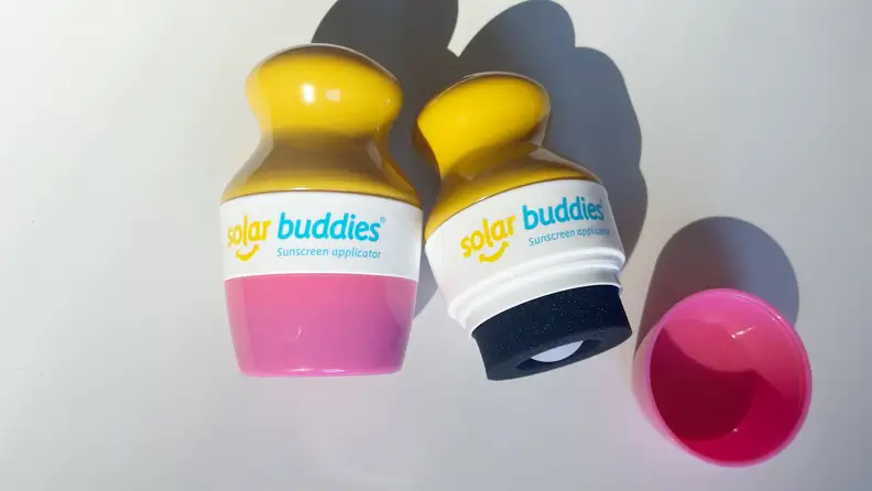 Two Solar Buddies Sunscreen applicators on a white background.
