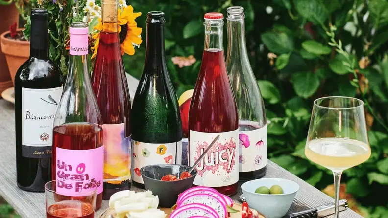 Bottles of red, white, and rosé wine arranged on a picnic table.