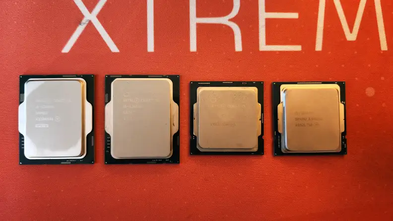 Four desktop computer processors arranged in a line on top of an orange mat.