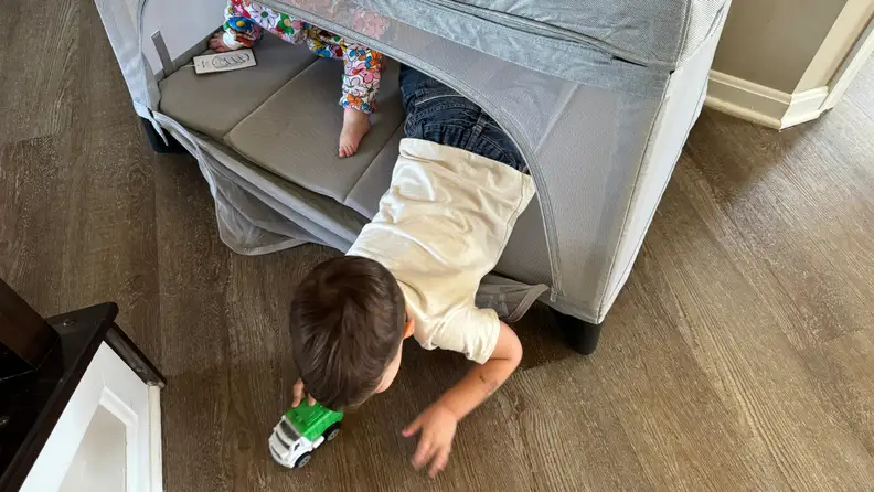 Two small toddlers playing inside of the Uppababy Remi playard.