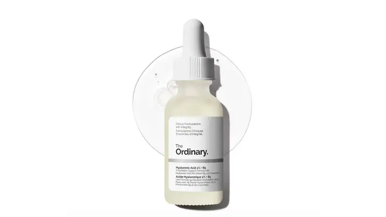 A clear bottle of serum on a white background