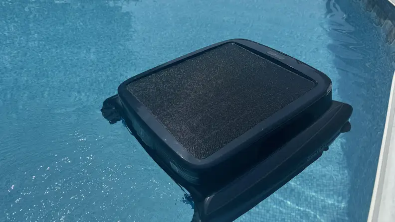 Black Beatbot iSkim shown floating on the water in a pool.