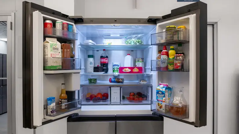 The Samsung Bespoke Family Hub Fridge with its fridge doors open and food inside.