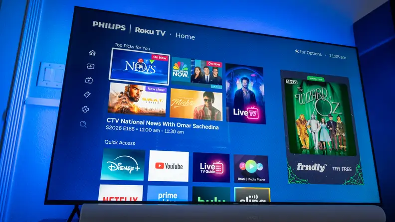 Philips Ambilight 7985 TV showing Roku streaming apps with blue ambient light behind the TV.