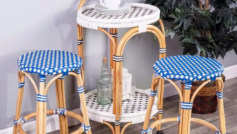 Two wicker stools with a wicker end table.