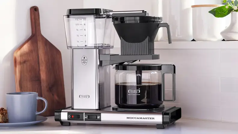 Polished silver Moccamaster coffee maker with a full glass carafe