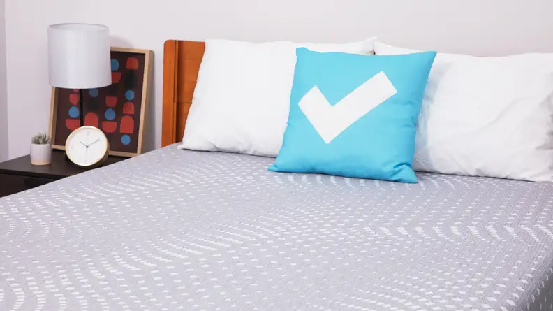 A closer view of the Sealy Posturepedic mattress with two pillows on top.