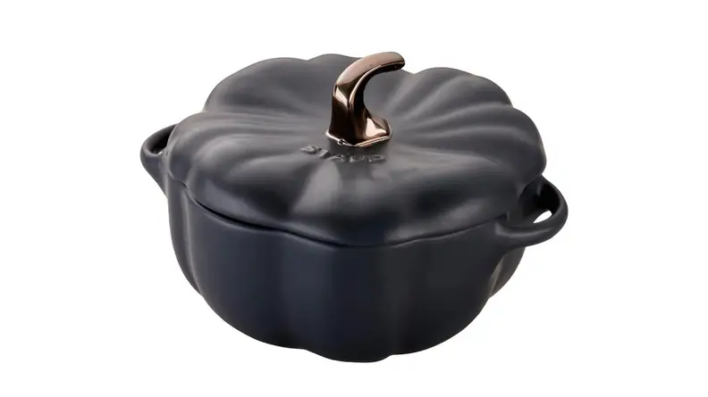 An image of a Staub Dutch oven in the shape of a pumpkin, with matte black and bronze accents