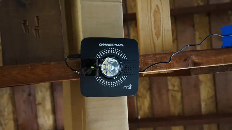 The Chamberlain Smart Garage Hub hangs in a garage.