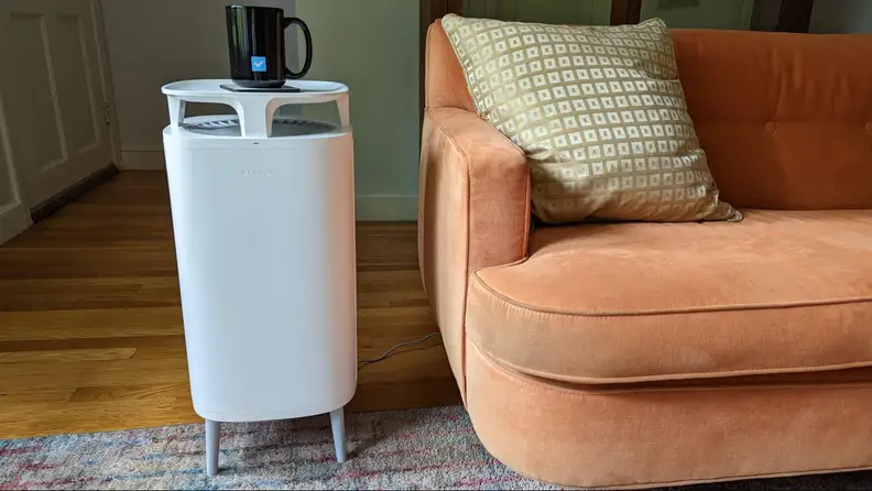 Air purifier sitting next to a couch