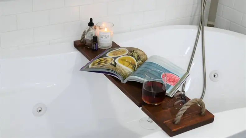 wooden bath caddy on white bathtub