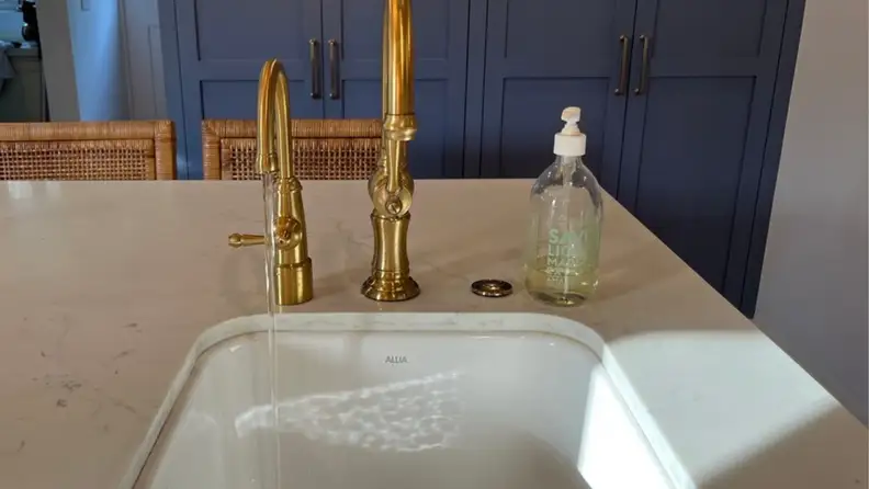 A kitchen faucet flows with water