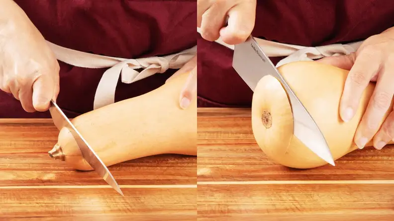 Person using sharp knife to remove top and bottom from butternut squash on top of wooden cutting board.