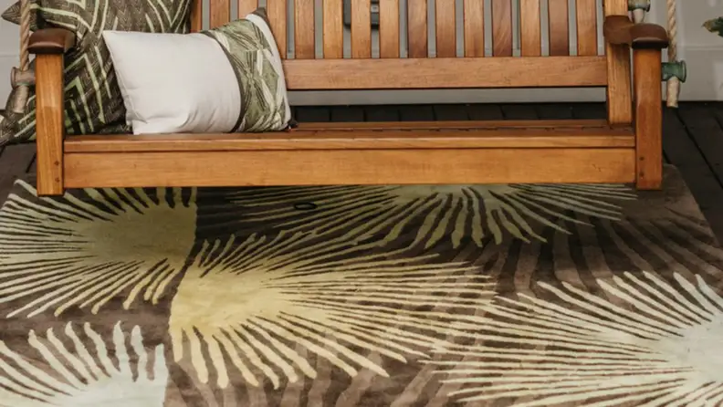 Bench with a brown and yellow Loulu area rug underneath
