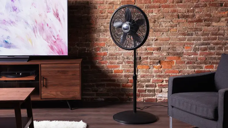 A shot of the fan in a living room, surrounded by furniture and a TV.