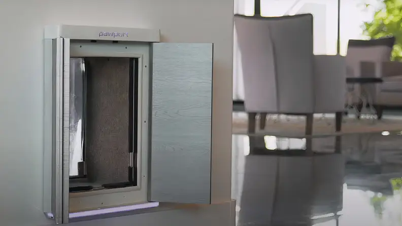 A sleek, modern pet door with a secure, automated design, featuring a brushed metal finish and a soft interior, seamlessly integrated into a home wall with a stylish and minimalistic interior in the background.