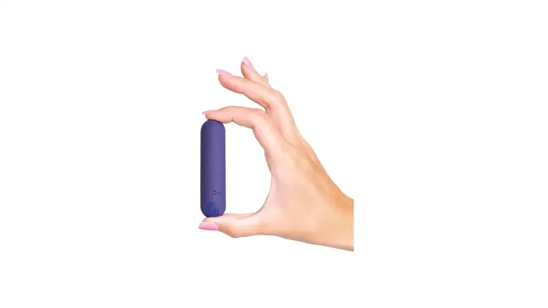 A hand holding a plusOne Bullet Vibrator in front of a white background.