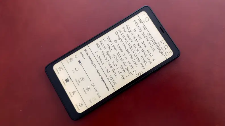 A Palma e-reader sits on a red leather tabletop.