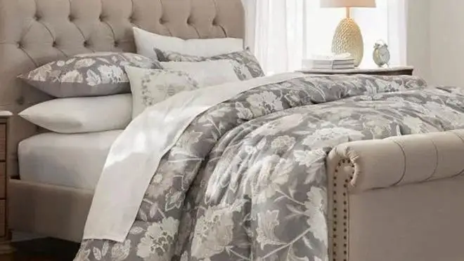 Close up of a bed with a gray bedspread.