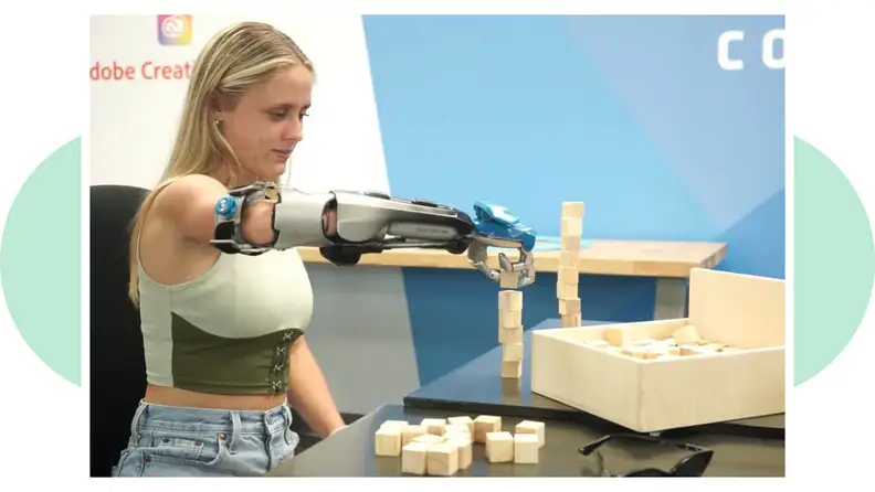 A person with a bionic arm from Limbitless Solutions works with blocks to get used to bond with the prosthetics.