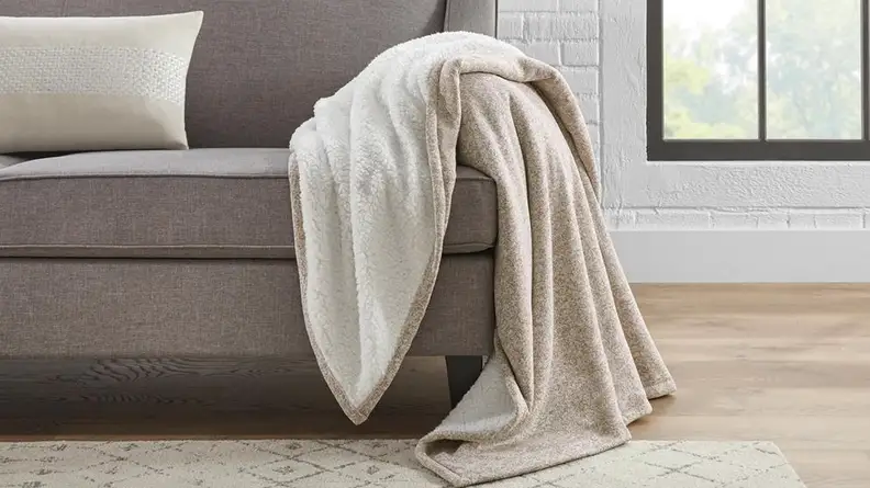 A fuzzy brown blanket thrown across a couch