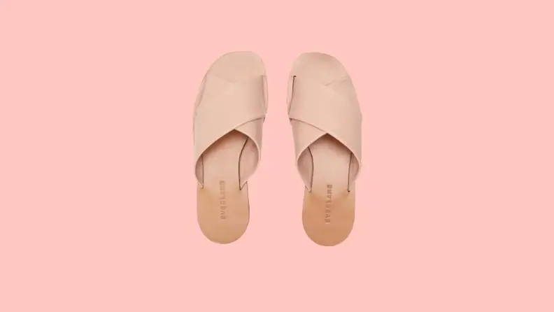 Slide-on sandals that feature crisscrossing pink straps.