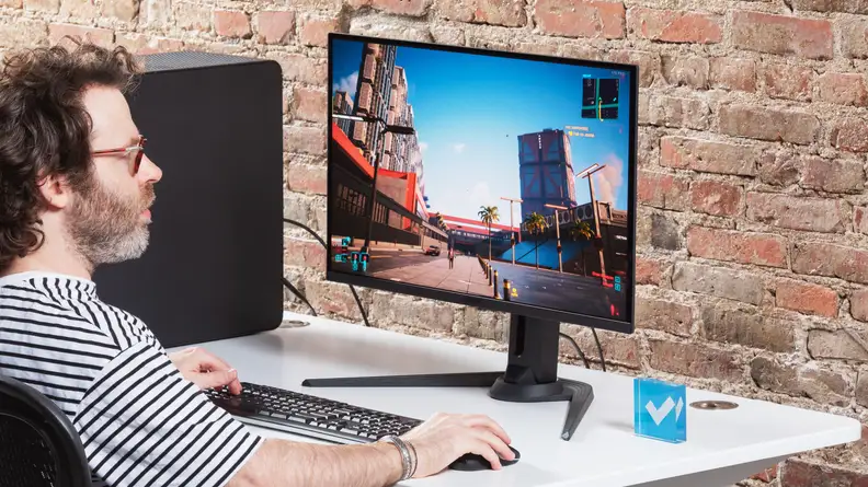 A person playing Cyberpunk 2077 on a Gigabyte AORUS FO27Q3 monitor.