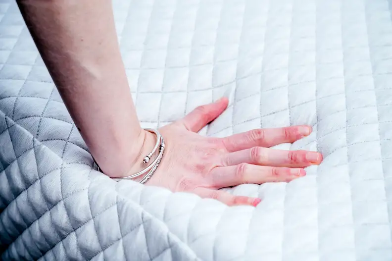a hand presses into the Leesa Hybrid surface
