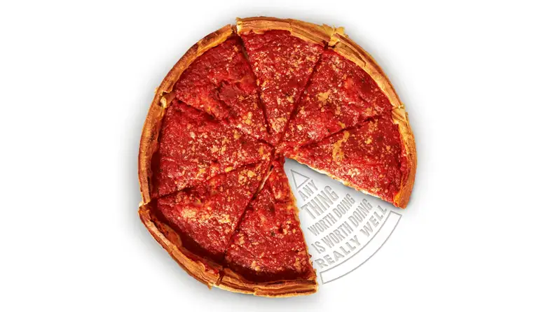 An overhead shot of a sliced deep-dish pizza with a slice missing