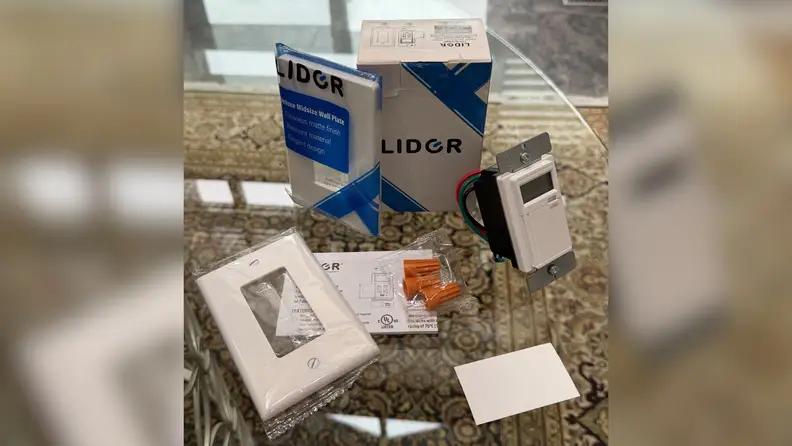 Packaging and accessories of Lider 7-Day Programmable Digital Timer Switch shown on a glass table.