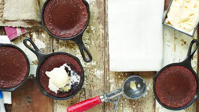 Multiple mini cast iron skillets with cooked skillet brownies on table