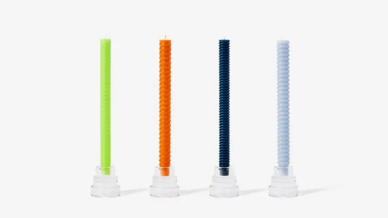 Four multicolored candles against a white background