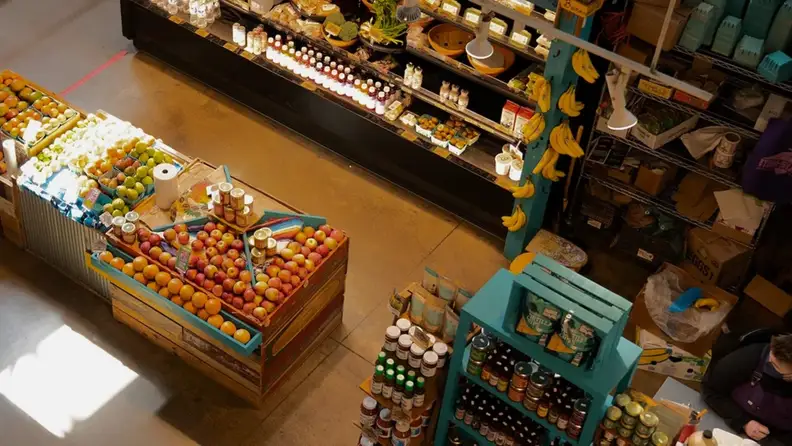 Overhead view of a produce stand with fruit and pantry goods