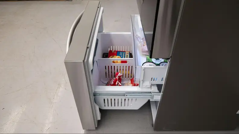 The freezer compartment open filled with frozen foods.