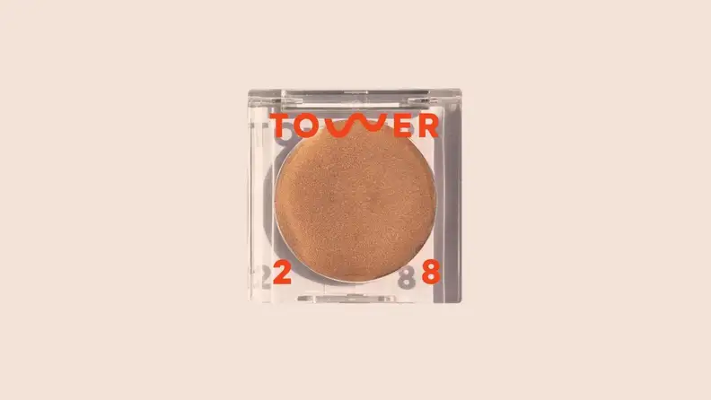 The Cream Bronzer in front of a background.