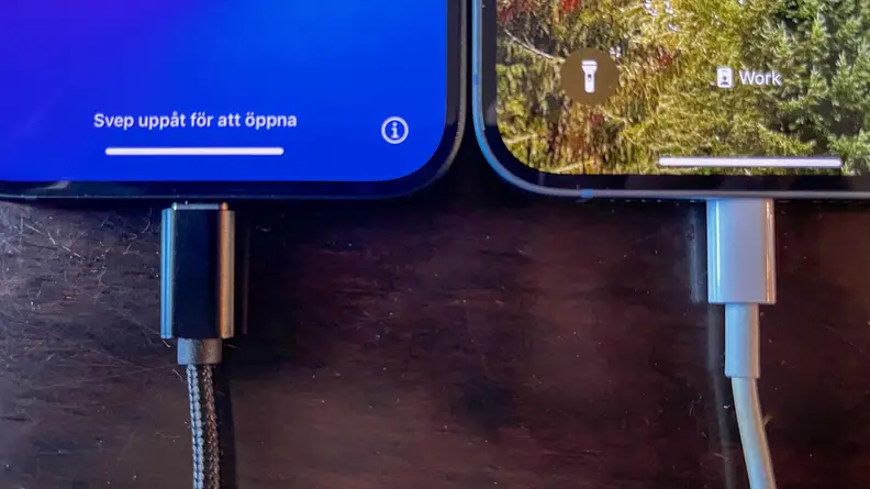 The iPhone 14 Plus and the iPhone 15 Plus connected to chargers, side-by-side.