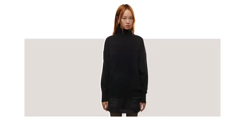 A model wearing a black turtleneck sweater.