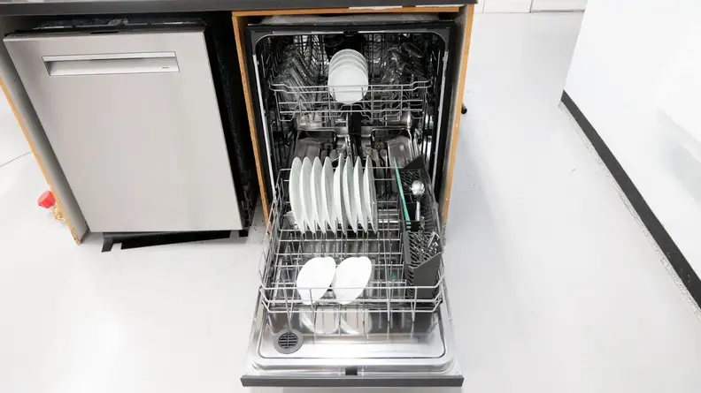 A shot of the dishwasher with its door opened fully and its lower rack pulled out. Both the lower and upper rack contain clean dishes.