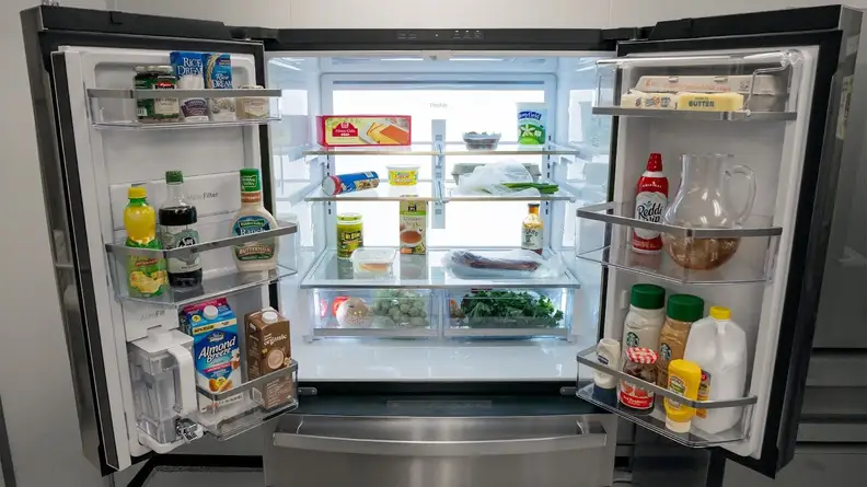 A shot of the interior of the fridge, each shelf and bin stacked with items, all illuminated by the LED backlight.