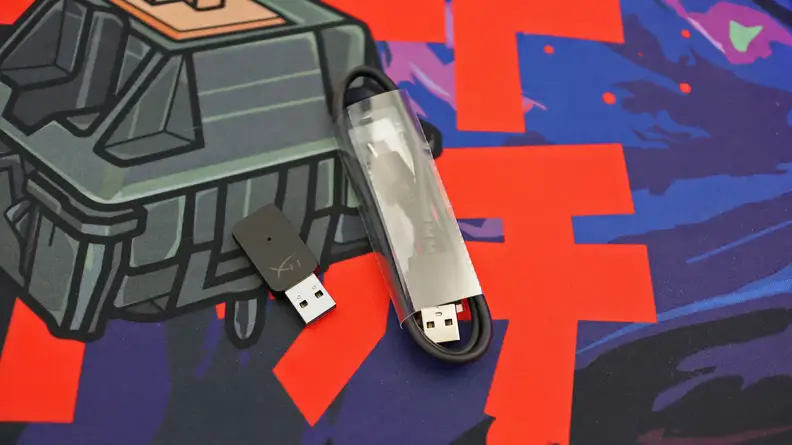 A close up of a USB cable wrapped in plastic and a small USB wireless adapter
